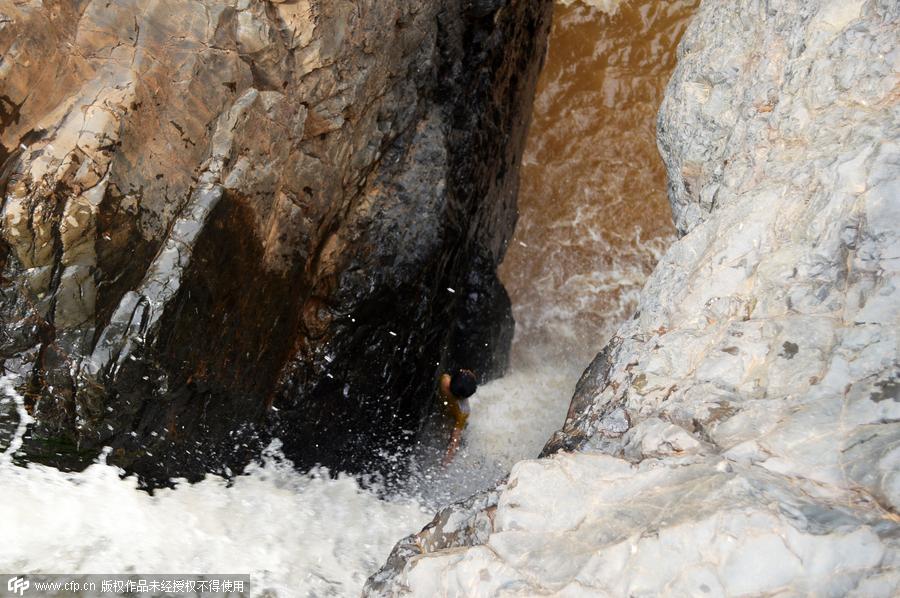 Boy plucked from cliff after falling into waterfall in SW China