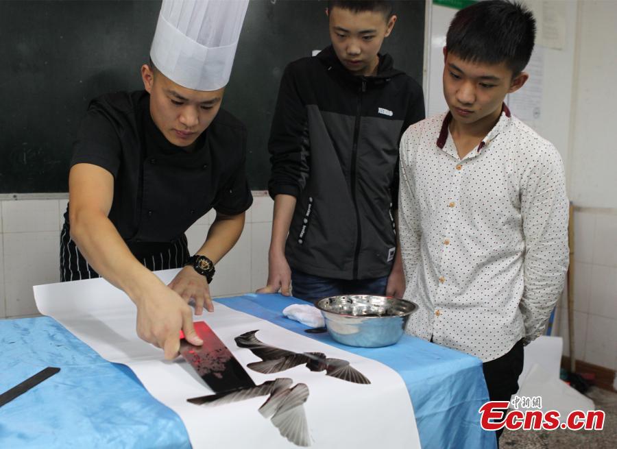 Man writes Chinese calligraphy using kitchenware