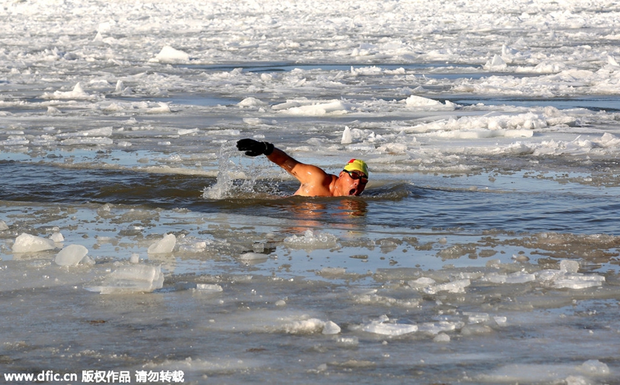 Swimmers battle against the cold in ice-covered river