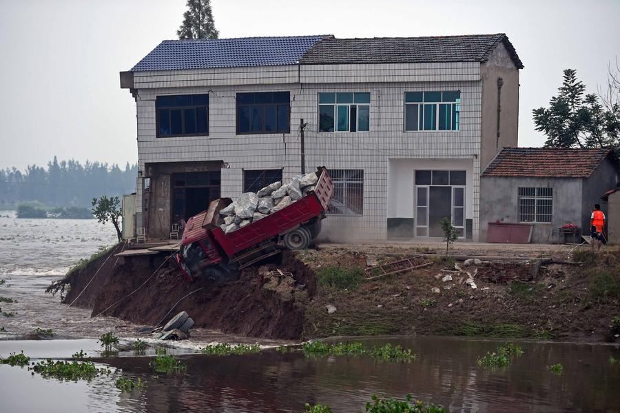 Rescuers risk life, drive heavy trucks to block floodwater