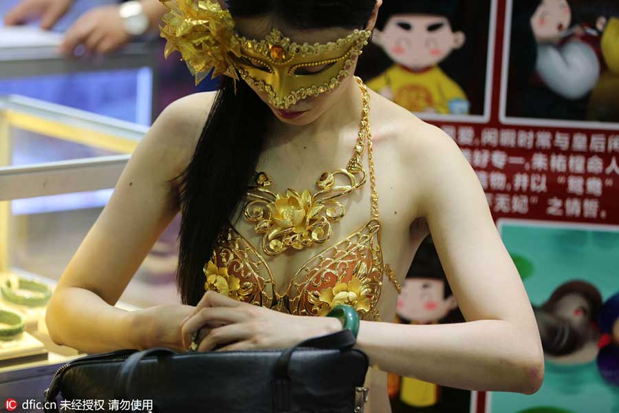 Model in golden bikini dazzles at jewelry exhibition