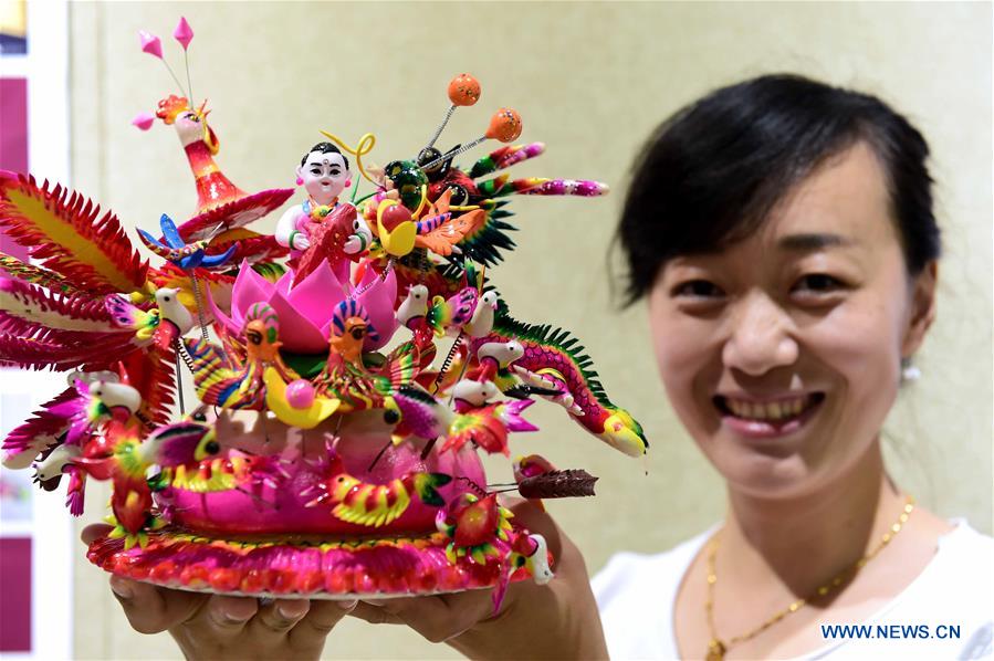 Delicate dough figurine work presented at craft workshop in Shandong