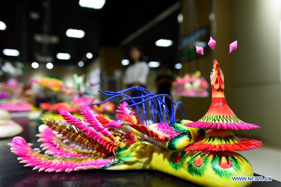 Delicate dough figurine work presented at craft workshop in Shandong