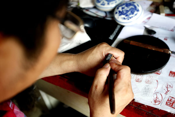 Man continues stamp carving despite struggling business