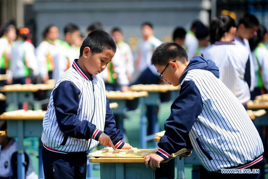 Pupils play Chinese chess during activity in NE China