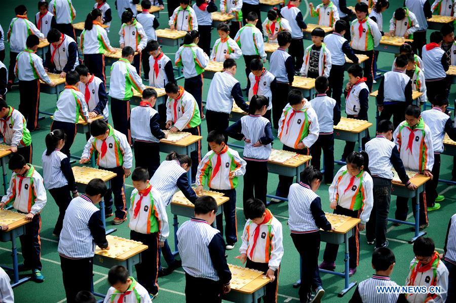 Pupils play Chinese chess during activity in NE China