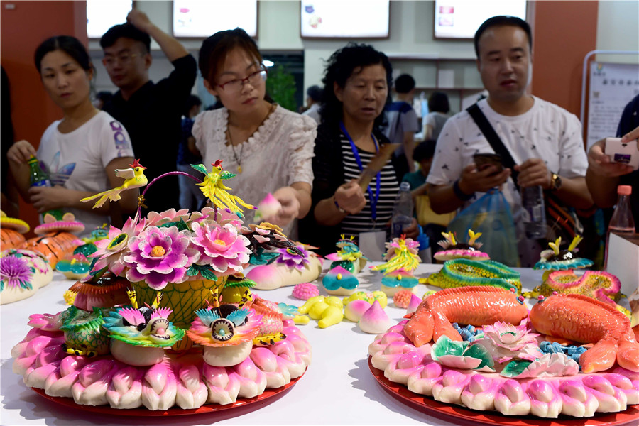 People view handicrafts at 4th China Intangible Cultural Heritage Expo in Jinan