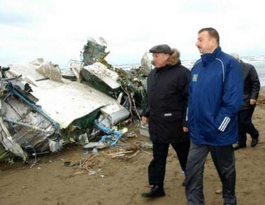 Azerbaijan's President Ilham Aliyev (R) attends a scene of Antonov An-140 plane crash at seashore at Nardaran, on the outskirts of Baku, December 24, 2005.