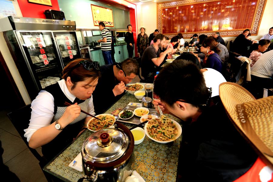 Tourists enjoy firecracker-shaped noodles in Zhangye, NW China's Gansu