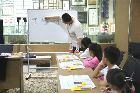 Children learn peach pit carving in Shandong