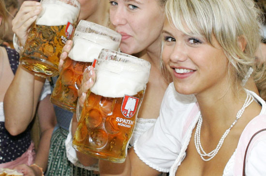 Young women in traditional Bavarian clothes toast with one-litre beer mugs during the opening day of the Oktoberfest in Munich in this September 17, 2005 file photo. The FIFA soccer World Cup 2006 final will be held in Germany from June 9 - July 9. 