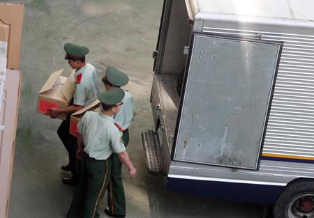 Chinese armed policemen stands guard as others move boxes of examination papers for the upcoming National College Entrance Examination, or gaokao, into a test center in Beijing, June 5, 2007. Chinese education authorities have taken a set of measures to clean up the exam environment, including requiring test-takers to sign written pledges and increasing security checks at exam venues. But still cheating is on the rise. In last year's national college exam, about 3,000 students were caught cheating, China Daily reported last week.[newsphoto]