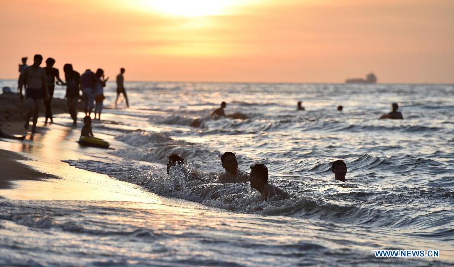 Haikou citizens play along beach in heat wave