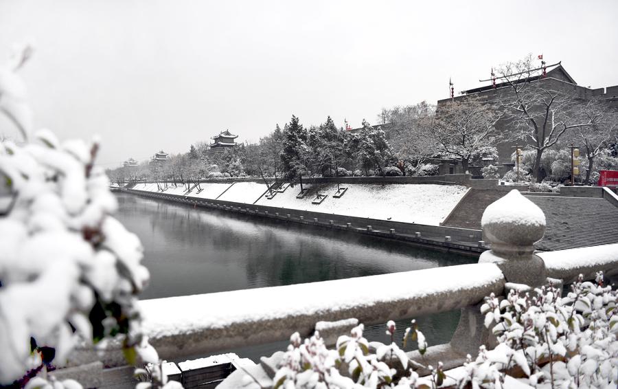 People enjoy snow scenery of ancient city Xi'an